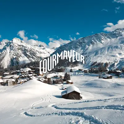 Courmayeur in inverno: panorama innevato con montagne, chalet e cielo azzurro. Località sciistica italiana sul Monte Bianco.