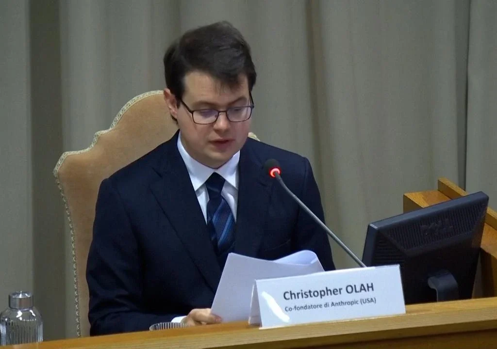 Christopher Olah, co-founder of Anthropic (USA), reads a document at the microphone.