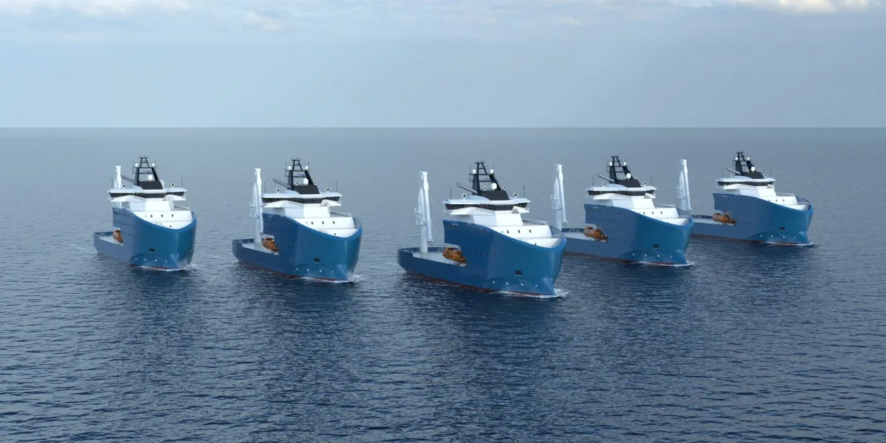 Cinque navi da lavoro Vard navigano in fila sul mare calmo, con scafi blu e sovrastrutture bianche sotto un cielo sereno.