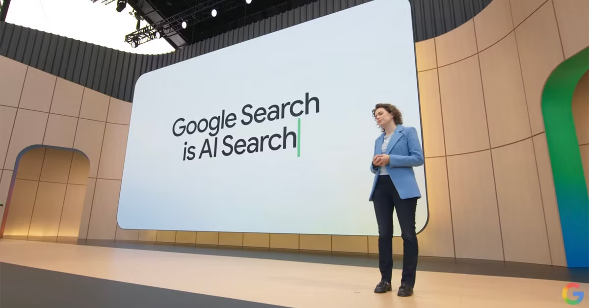 Donna in giacca blu presenta 'Google Search is AI Search' su uno schermo largo durante un evento.